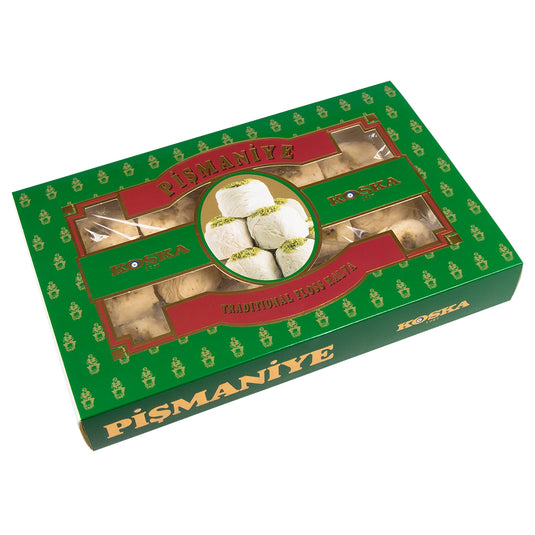 KOSKA pismaniye, une confiserie turque traditionnelle semblable à de la barbe à papa, composée de fins filaments sucrés dorés et légèrement brillants, disposés en petits amas moelleux. La texture aérienne et fondante contraste avec son aspect délicatement fibreux. L’arrière-plan est flou, mettant en valeur la douceur et l’élégance de cette gourmandise orientale.