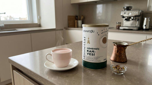 Tasse de café menengiç fumant beige-rosé à côté du paquet Menengiç ŞEKEROĞLU et d'un cezve en cuivre
