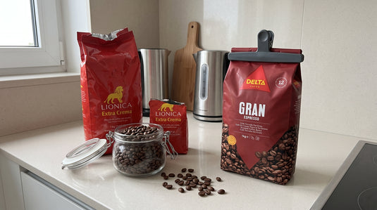 Paquets de café en grains LIONICA et Delta Gran Espresso posés à côté d'un bocal hermétique rempli de grains de café, sur un plan de travail de cuisine