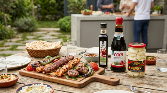 Table de grillades d'été avec les bouteilles réelles de mélasse de grenade DOGANAY et le bocal de tursu ail CENKCI
