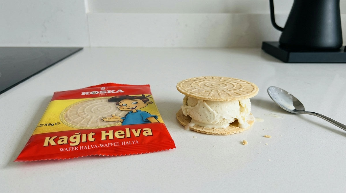 Paquet de Kağıt Helva KOSKA à côté d'un mini sandwich glacé fait avec deux gaufrettes rondes et une boule de glace, sur un plan de travail de cuisine moderne