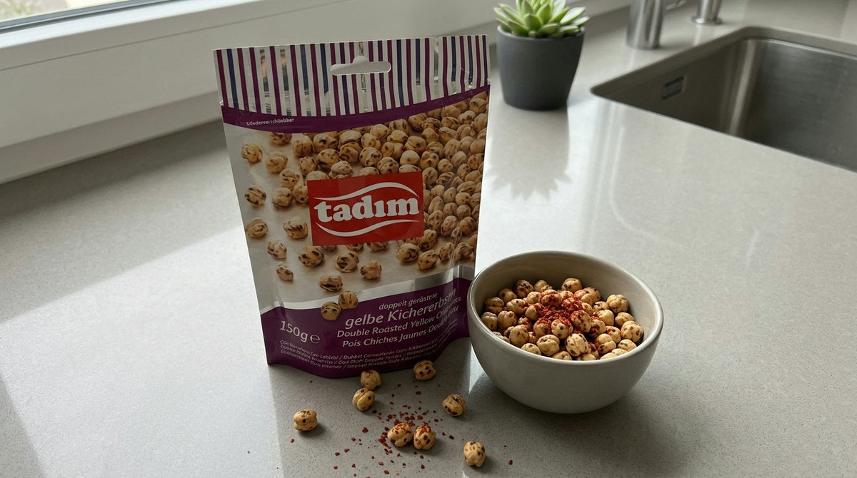 Sachet de Leblebi TADIM (pois chiches jaunes double rôti) à côté d'un bol de leblebi saupoudré d'épices, sur un plan de travail de cuisine moderne