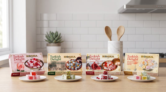 Quatre loukoums KOSKA (rose, pistache, grenade, multi-saveurs) présentés côte à côte sur un plan de travail en bois