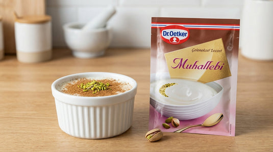 Ramequin de muhallebi saupoudré de cannelle et pistaches, posé à côté du sachet DR. OETKER