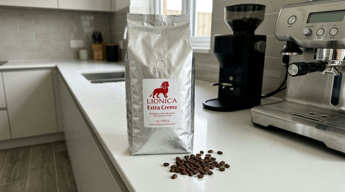 Sachet de café en grains LIONICA Extra Crema posé sur un plan de travail de cuisine moderne, à côté d'un broyeur et d'une machine expresso