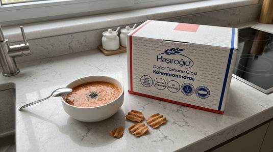 Bol de soupe tarhana avec quelques chips de tarhana à côté de la boîte HASIROGLU Doğal Tarhana Cipsi sur un plan de travail de cuisine