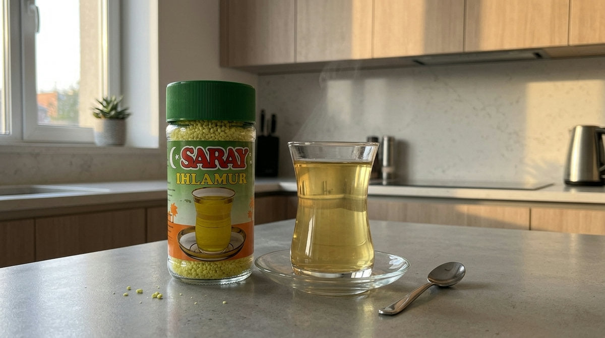 Verre de thé instantané au tilleul avec le pot SARAY Ihlamur 200g posé sur un plan de travail de cuisine moderne